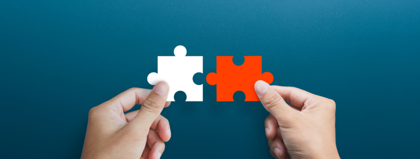 Businessman,Hands,Connecting,Puzzle,Pieces,Representing,The,Merging,Of,Two